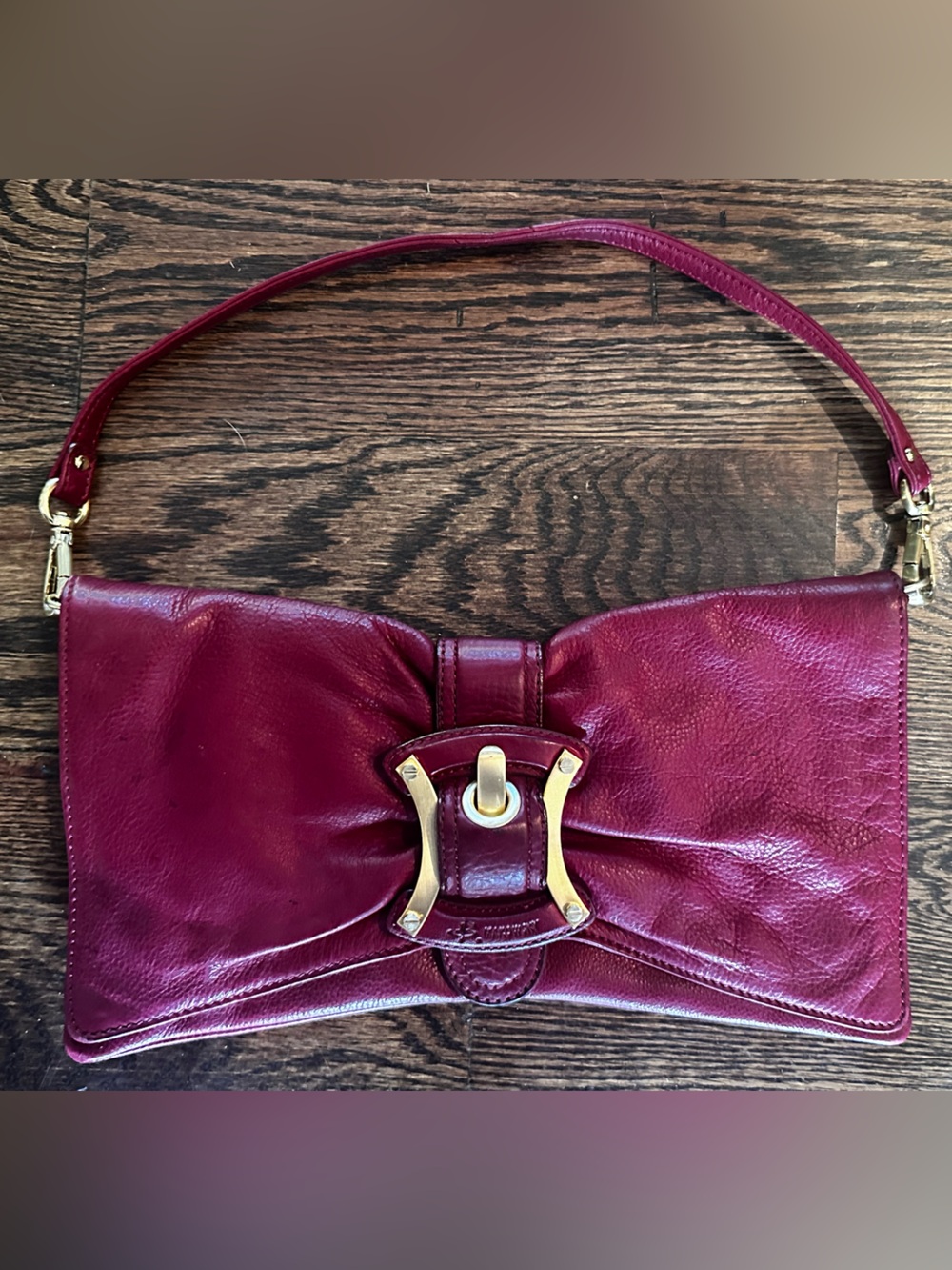 B. Makowsky red leather clutch with gold hardware
